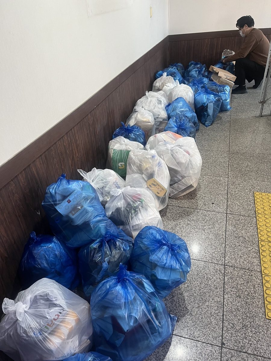 공용 복도 벽을 따라 파란색·흰색 종량제봉투 수십 개가 줄지어 배출된 모습